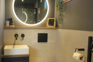 Private cabin bathroom Cabin bathroom with a round illuminated mirror and basin